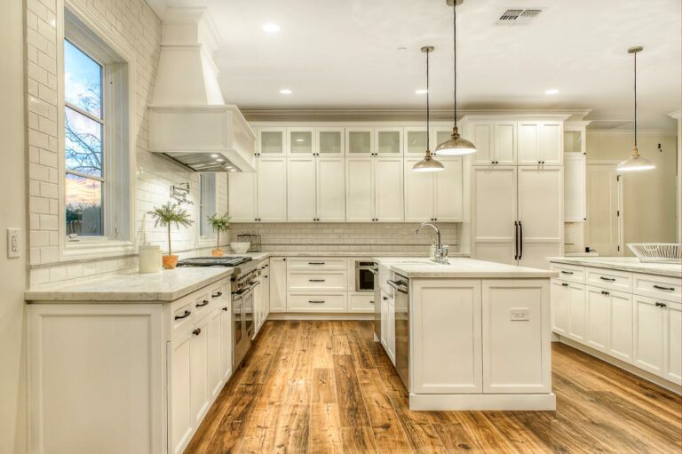 Luxury custom white kitchen with marble countertops, hardwood floors, and modern cabinetry by Cerwood Custom Cabinetry.